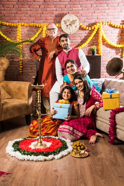 Ganesh Festivali 'ni ya da Chaturthi' yi kutlayan mutlu Hint Ailesi - Hoş geldiniz ya da Pooja 'yı sahneleyen ve geleneksel olarak Marigold Çiçekleri ile süslenmiş evde şekerleme yiyen