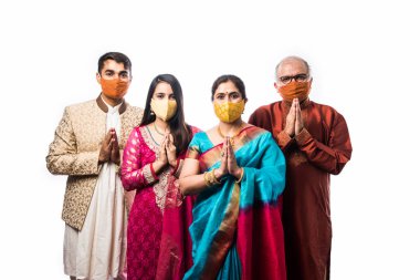 Koronavirüs ve grip salgınından sonra dört kişilik Hint ailesi koruyucu tıbbi yüz maskesi festivalleri düzenliyor. Virüs ve hastalık koruması, karantina. COVID-2019. beyaz arkaplan üzerinde izole