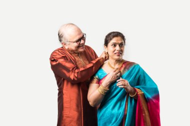 Hintli yaşlı adam doğum gününde, sevgililer gününde, yıldönümünde ya da Diwali festivalinde güzel karısına altın kolye takıyor ya da sunuyor.