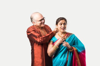 Hintli yaşlı adam doğum gününde, sevgililer gününde, yıldönümünde ya da Diwali festivalinde güzel karısına altın kolye takıyor ya da sunuyor.