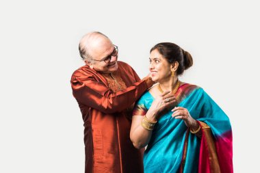 Hintli yaşlı adam doğum gününde, sevgililer gününde, yıldönümünde ya da Diwali festivalinde güzel karısına altın kolye takıyor ya da sunuyor.