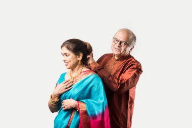 Hintli yaşlı adam doğum gününde, sevgililer gününde, yıldönümünde ya da Diwali festivalinde güzel karısına altın kolye takıyor ya da sunuyor.