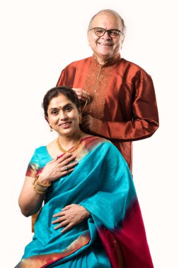 Hintli yaşlı adam doğum gününde, sevgililer gününde, yıldönümünde ya da Diwali festivalinde güzel karısına altın kolye takıyor ya da sunuyor.