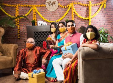 Koronavirüs ve grip salgını festivalinde koruyucu tıbbi maske takan Hintli bir aile. Virüs ve hastalık koruması, karantina. COVID-2019