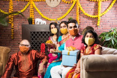 Koronavirüs ve grip salgını festivalinde koruyucu tıbbi maske takan Hintli bir aile. Virüs ve hastalık koruması, karantina. COVID-2019