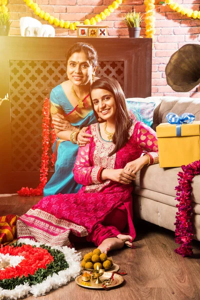 Ganesh Festivali 'ni ya da Chaturthi' yi kutlayan mutlu Hint Ailesi - Hoş geldiniz ya da Pooja 'yı sahneleyen ve geleneksel olarak Marigold Çiçekleri ile süslenmiş evde şekerleme yiyen