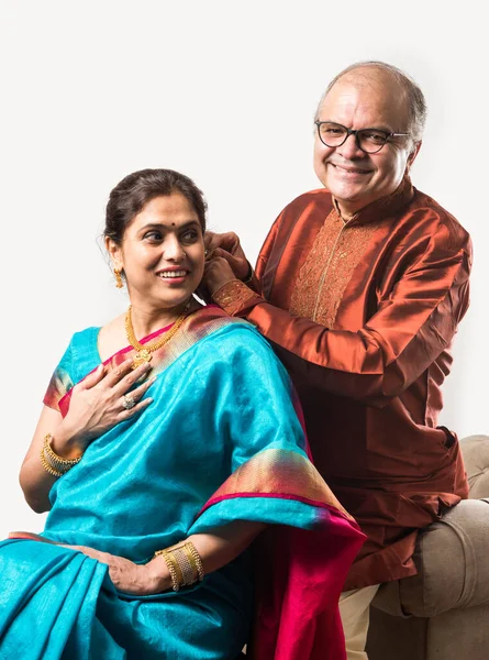 Hintli yaşlı adam doğum gününde, sevgililer gününde, yıldönümünde ya da Diwali festivalinde güzel karısına altın kolye takıyor ya da sunuyor.