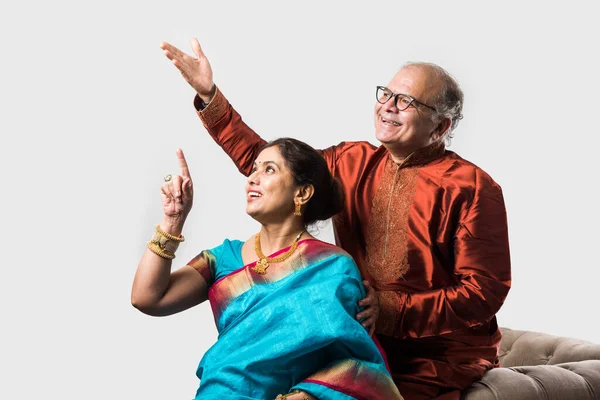 Geleneksel giyinmiş, beyaz arka planda izole edilmiş mutlu Hintli son sınıf ya da emekli çift portresi