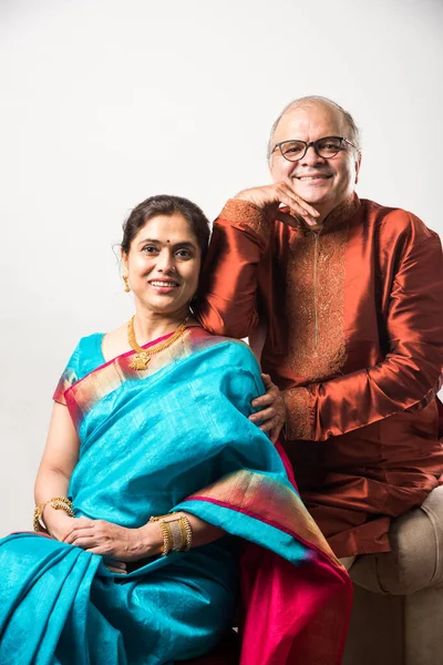 Geleneksel giyinmiş, beyaz arka planda izole edilmiş mutlu Hintli son sınıf ya da emekli çift portresi