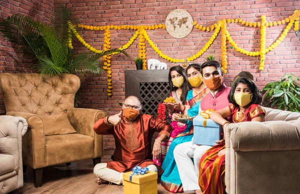 Koronavirüs ve grip salgını festivalinde koruyucu tıbbi maske takan Hintli bir aile. Virüs ve hastalık koruması, karantina. COVID-2019