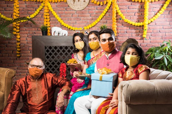 Koronavirüs ve grip salgını festivalinde koruyucu tıbbi maske takan Hintli bir aile. Virüs ve hastalık koruması, karantina. COVID-2019