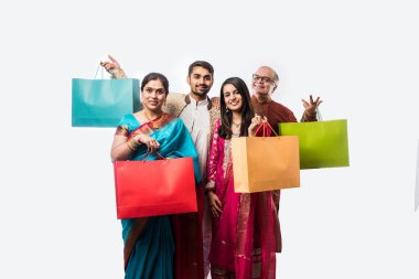 Neşeli Hintli aile Diwali festivali ya da düğünü için alışveriş yapıyor. Renkli kağıt torbaları gösteriyor.