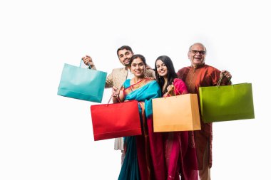 Neşeli Hintli aile Diwali festivali ya da düğünü için alışveriş yapıyor. Renkli kağıt torbaları gösteriyor.