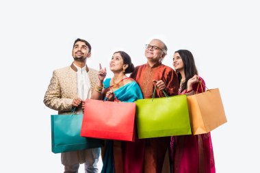 Neşeli Hintli aile Diwali festivali ya da düğünü için alışveriş yapıyor. Renkli kağıt torbaları gösteriyor.