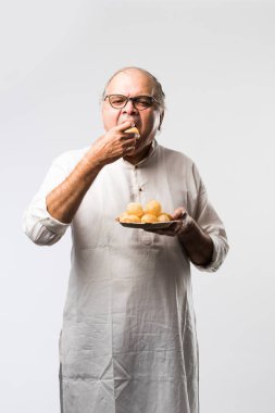 Hintli yaşlı adam panipuri, phuchka, gupchup veya golgappa yer.