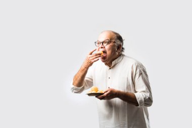 Hintli yaşlı adam panipuri, phuchka, gupchup veya golgappa yer.