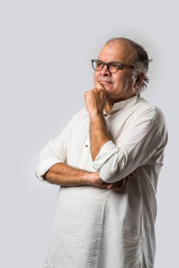 Mutlu Hintli emekli bir adamın portresi beyaz kurta giyer, işaret eder, sunar ya da katlanmış poz verir.