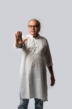 Mutlu Hintli emekli bir adamın portresi beyaz kurta giyer, işaret eder, sunar ya da katlanmış poz verir.