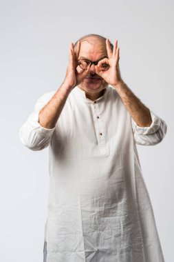 Mutlu Hintli emekli bir adamın portresi beyaz kurta giyer, işaret eder, sunar ya da katlanmış poz verir.