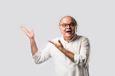 Mutlu Hintli emekli bir adamın portresi beyaz kurta giyer, işaret eder, sunar ya da katlanmış poz verir.