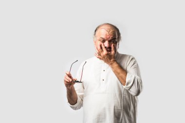 Hintli Asyalı yaşlı adamın farklı yerlerinde ağrı ya da ağrı var. Hüzünlü ifadeler.