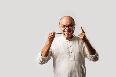 Kıdemli Hintli adam taze yeşil salata yiyor. Olgun erkek sağlıklı beslenme, sağlık, beslenme konsepti