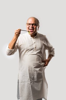 Kıdemli Hintli adam taze yeşil salata yiyor. Olgun erkek sağlıklı beslenme, sağlık, beslenme konsepti