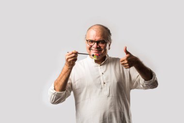 Kıdemli Hintli adam taze yeşil salata yiyor. Olgun erkek sağlıklı beslenme, sağlık, beslenme konsepti