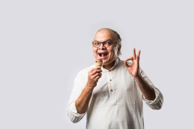 Hintli yaşlı adam çikolatalı dondurma yiyor dondurma ya da mango şekeri