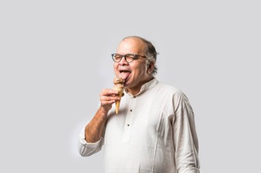 Hintli yaşlı adam çikolatalı dondurma yiyor dondurma ya da mango şekeri