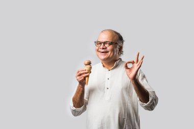 Hintli yaşlı adam çikolatalı dondurma yiyor dondurma ya da mango şekeri