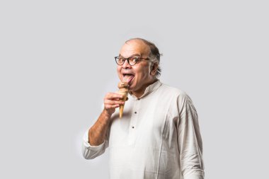 Hintli yaşlı adam çikolatalı dondurma yiyor dondurma ya da mango şekeri