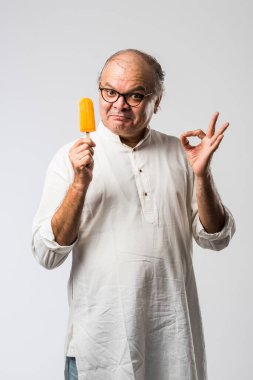 Hintli yaşlı adam çikolatalı dondurma yiyor dondurma ya da mango şekeri