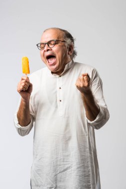 Hintli yaşlı adam çikolatalı dondurma yiyor dondurma ya da mango şekeri