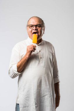 Hintli yaşlı adam çikolatalı dondurma yiyor dondurma ya da mango şekeri