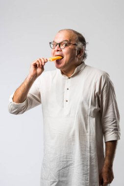Hintli yaşlı adam çikolatalı dondurma yiyor dondurma ya da mango şekeri