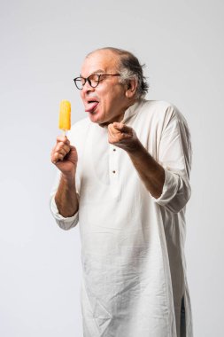 Hintli yaşlı adam çikolatalı dondurma yiyor dondurma ya da mango şekeri