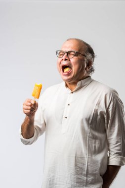 Hintli yaşlı adam çikolatalı dondurma yiyor dondurma ya da mango şekeri