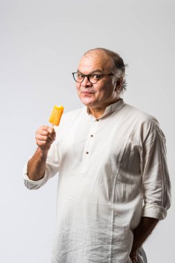 Hintli yaşlı adam çikolatalı dondurma yiyor dondurma ya da mango şekeri
