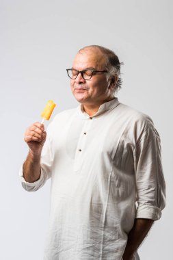 Hintli yaşlı adam çikolatalı dondurma yiyor dondurma ya da mango şekeri