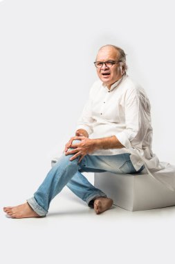 Hintli Asyalı yaşlı adamın farklı yerlerinde ağrı ya da ağrı var. Hüzünlü ifadeler.