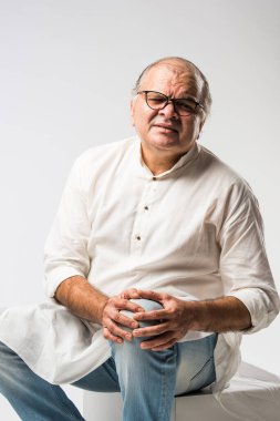 Hintli Asyalı yaşlı adamın farklı yerlerinde ağrı ya da ağrı var. Hüzünlü ifadeler.