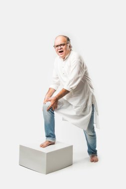 Hintli Asyalı yaşlı adamın farklı yerlerinde ağrı ya da ağrı var. Hüzünlü ifadeler.