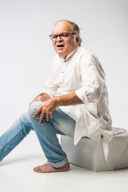 Hintli Asyalı yaşlı adamın farklı yerlerinde ağrı ya da ağrı var. Hüzünlü ifadeler.