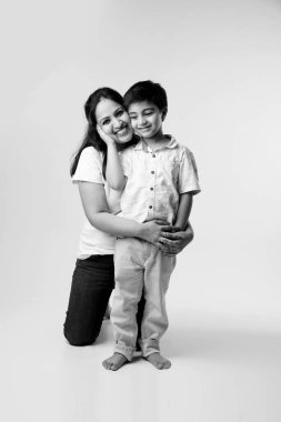 Beyaz arka plana bakan Hintli anne ve çocuğun portresi, kameraya bakıyor.