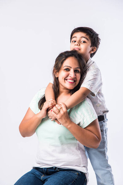 Портрет индийской молодой матери и сына на белом фоне, глядя в камеру