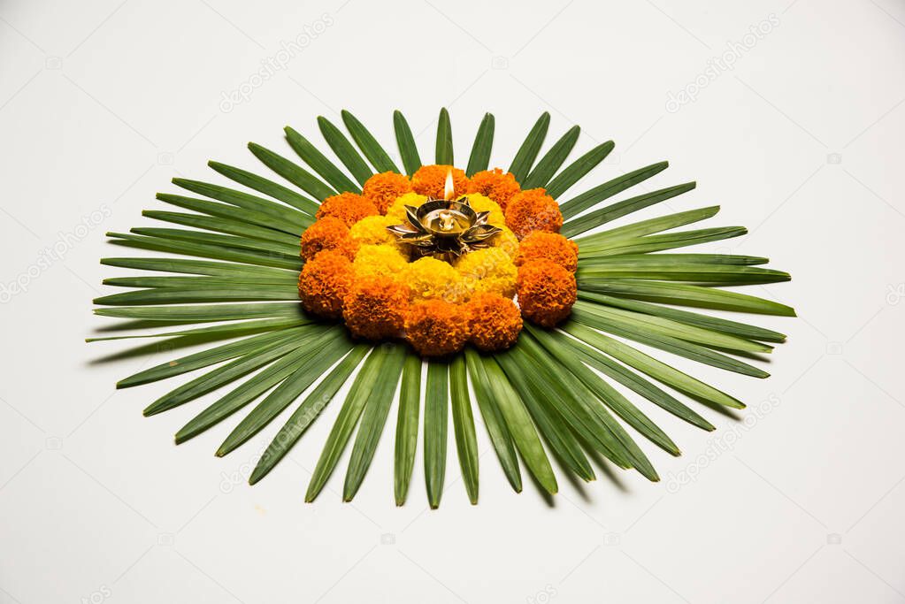 Flower Rangoli for Diwali or Pongal Festival made using Marigold or Zendu flowers and Rose petals over moody or white background, selective focus