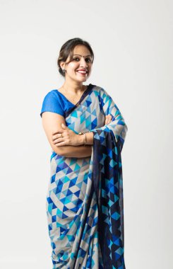 Sari ya da sari giymiş başarılı bir Hintli genç kadın portresi, elleri katlı ya da baş parmakları yukarıda, beyaz arka planda izole edilmiş.