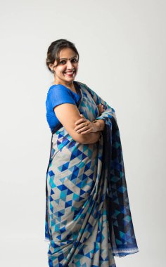 Sari ya da sari giymiş başarılı bir Hintli genç kadın portresi, elleri katlı ya da baş parmakları yukarıda, beyaz arka planda izole edilmiş.