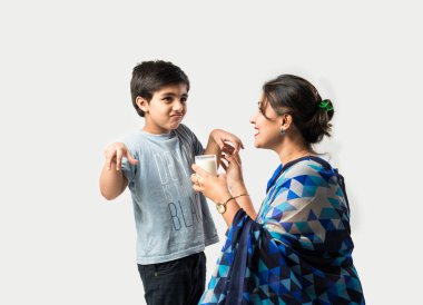 Hintli güzel anne oğluna bardakta süt içiriyor.